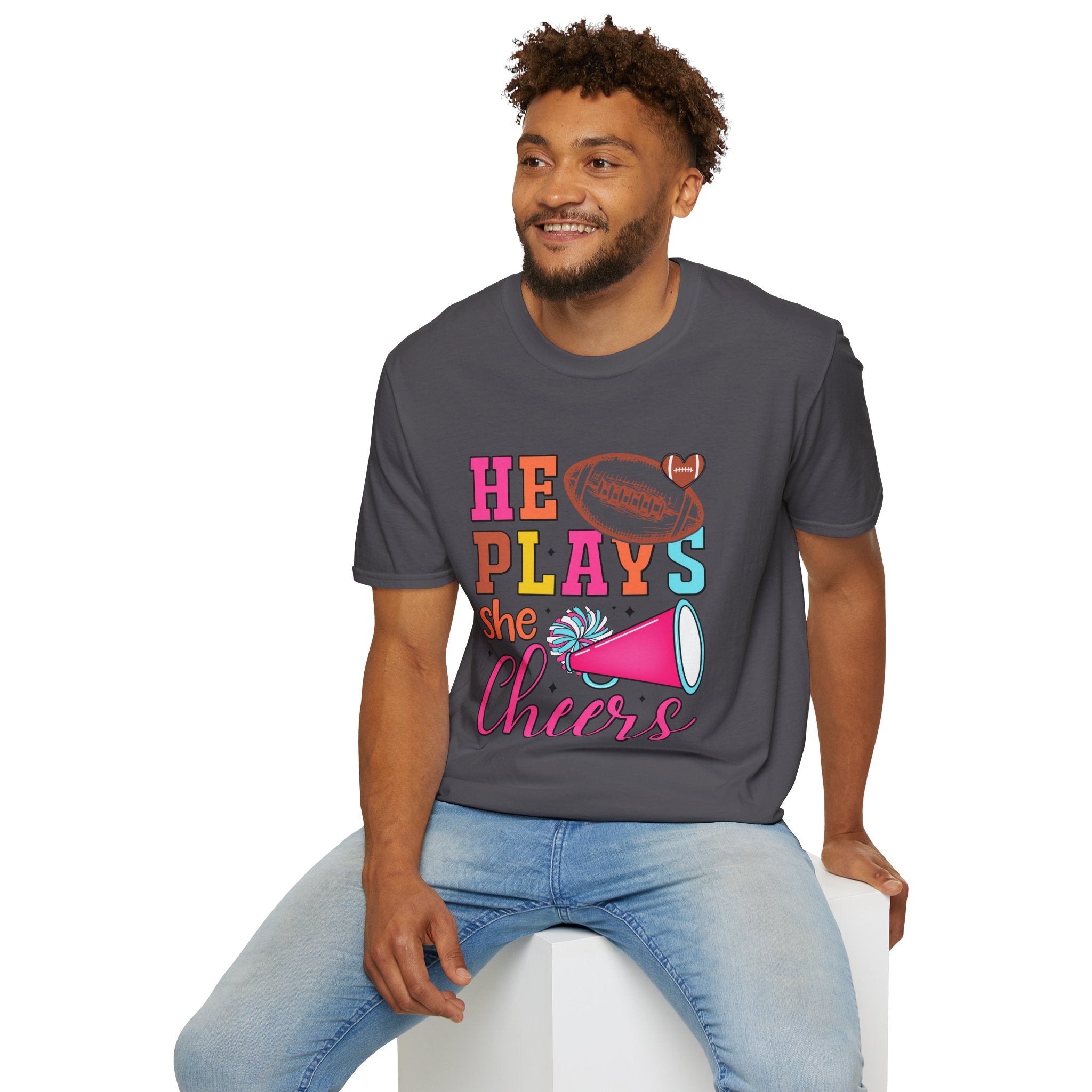 HE PLAYS, SHE CHEERS,  Unisex Softstyle T-Shirt | Supportive Gift for Cheerleading Parents, Sports Events, Game Day Tee